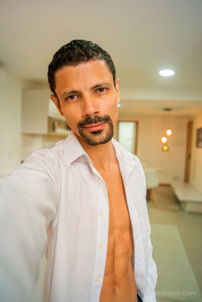 O fotógrafo Dyego Ribeiro olhando diretamente para a câmera em retrato lifestyle focado na direção de modelos.