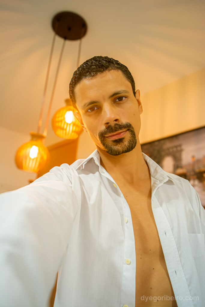 Retrato intimista do fotógrafo Dyego Ribeiro em ambiente interno com luz natural, demonstrando o uso da luz na fotografia sensual.